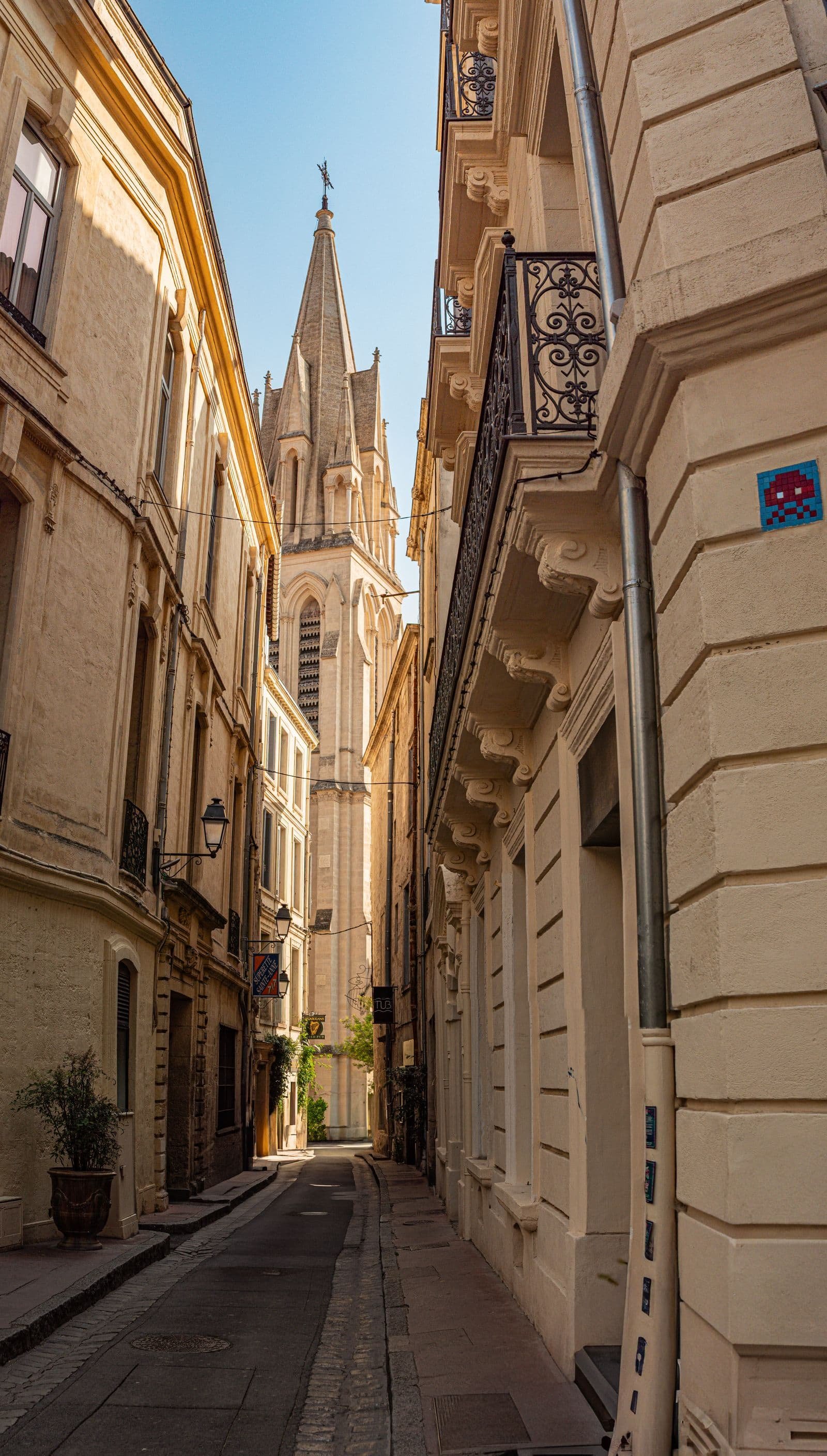 Rue étroite du centre historique de Montpellier menant à une église ancienne